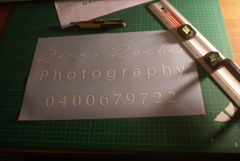 Custom vinyl lettering job piece prepared for application